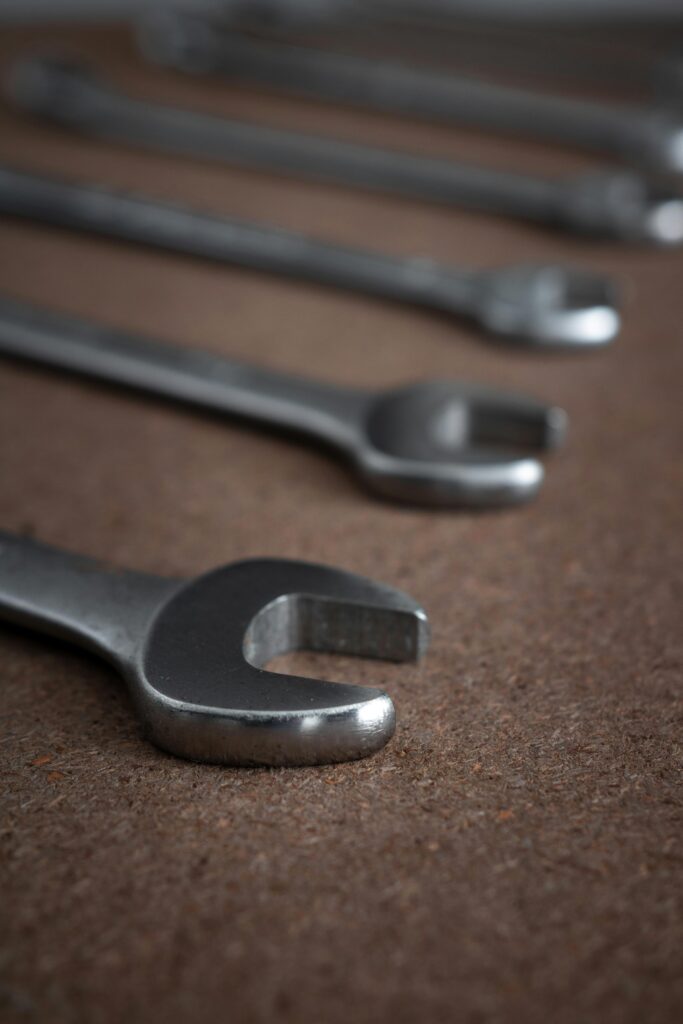 A detailed close-up of chrome wrenches arranged artistically on a textured surface, perfect for industrial themes.